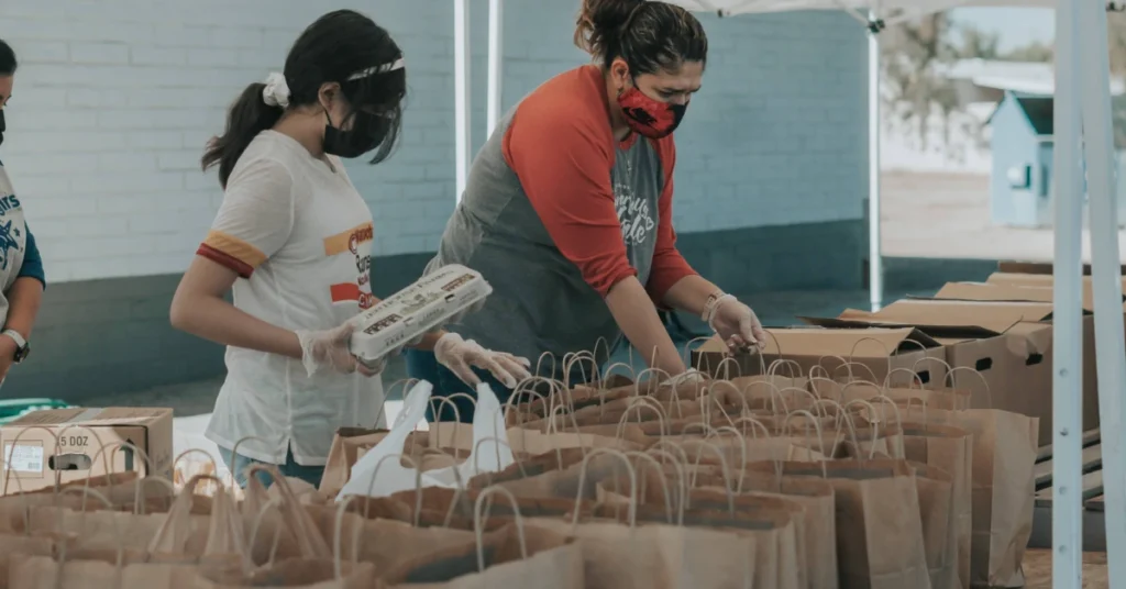 25+ Thanksgiving Gift Ideas for Teachers 2024 to Show Appreciation 5 two woman packing things in paper bags